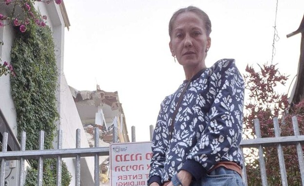 יאנה מחוץ לבניין ההרוס