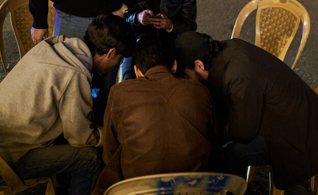 בני נוער מסתכלים בטלפונים בזמן המלחמה עם איראן