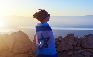 אישה עטופה בדגל ישראל (צילום: ECOSY, shutterstock)