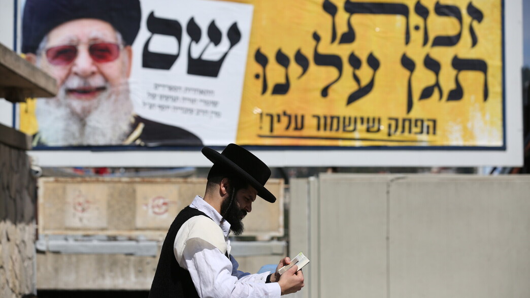 חרדי לצד שלט של ש"ס עם הרב עובדיה יוסף חרדי לצד שלט של ש"ס עם הרב עובדיה יוסף