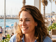 אישה יושבת בבית קפה ליד הים