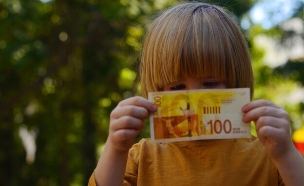 ילד מחזיק שטר של 100 שקל (אילוסטרציה: ShU studio, shutterstock)