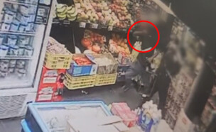 השודד מנפץ בקבוק על ראשו של המוכר