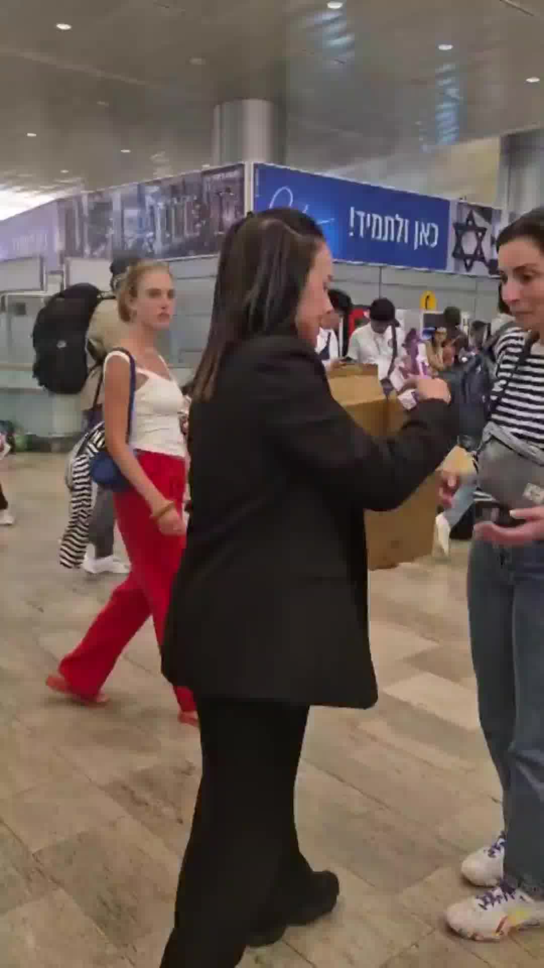 מתוק אבל פחות: עובדת רשות שדות התעופה מחלקת קרטיבים לנוסעים הזועמים