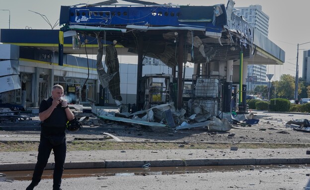 שוטר מעשן ליד תחנת דלק שנפגעה בתקיפת כטב"ם רוסית שוטר מעשן ליד תחנת דלק שנפגעה בתקיפת כטב"ם רוסית